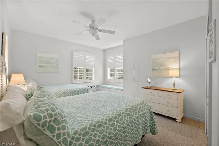 Carpeted bedroom featuring ceiling fan