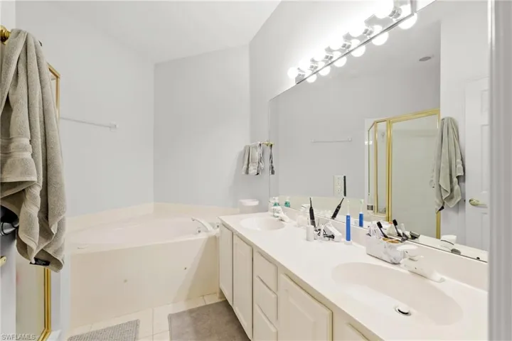 Bathroom with vanity, independent shower and bath, and tile patterned flooring