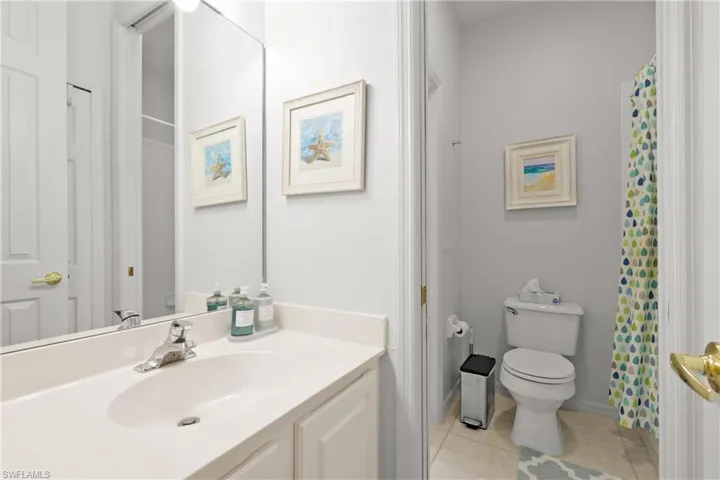 Bathroom featuring toilet, vanity, and tile patterned flooring