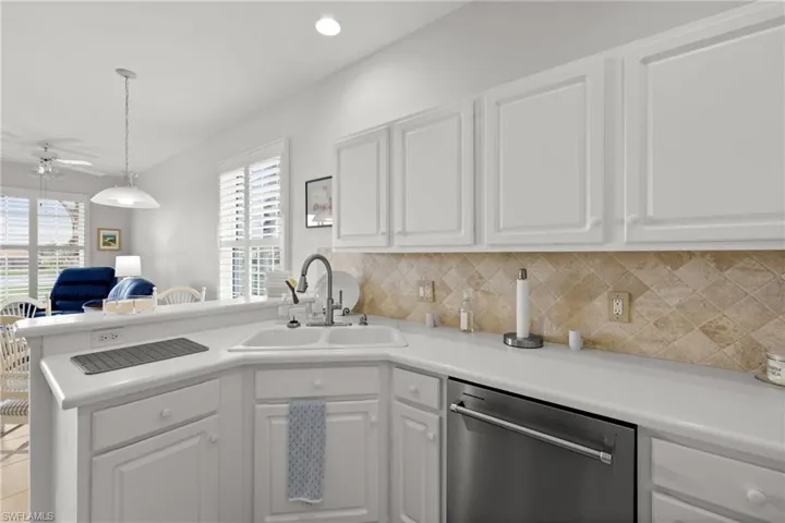 Kitchen featuring white cabinetry, a healthy amount of sunlight, sink, and stainless steel dishwasher
