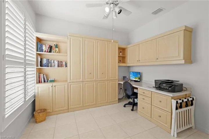 Tiled office space with built in desk and ceiling fan