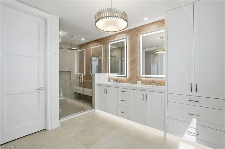 Full bathroom featuring double vanity, a stall shower, light tile patterned floors, and recessed lighting