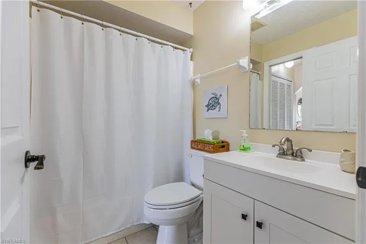 Bathroom featuring vanity, light tile patterned flooring, and a shower with shower curtain