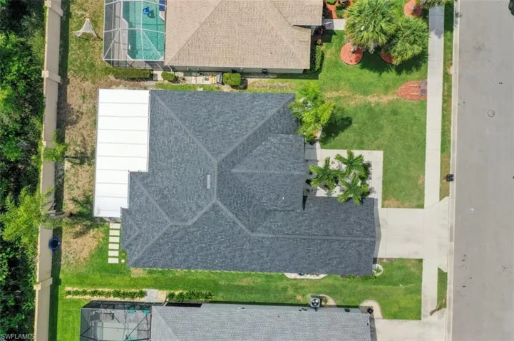 View of front facade featuring an attached garage, stucco siding, concrete driveway, central AC unit, and a front yard