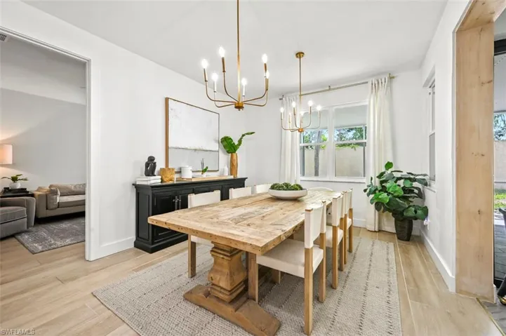 Dining space with a chandelier, light wood finished floors, and baseboards