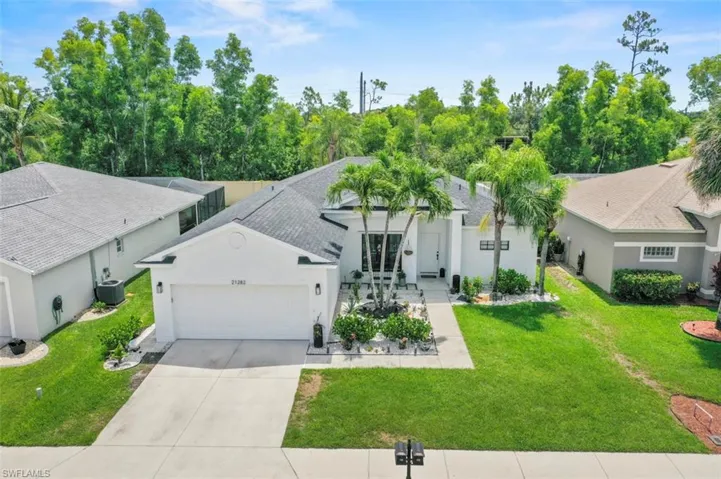 View of front of house with a garage, driveway, a front yard, and stucco siding