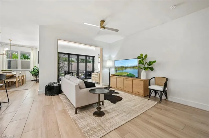 Living room featuring light wood-style floors, healthy amount of natural light, ceiling fan, and baseboards