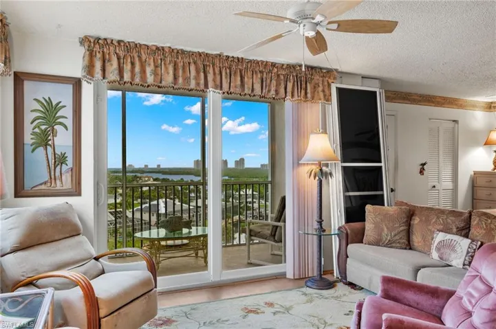 Living room featuring ceiling fan, a textured ceiling, and light hardwood / wood-style floors