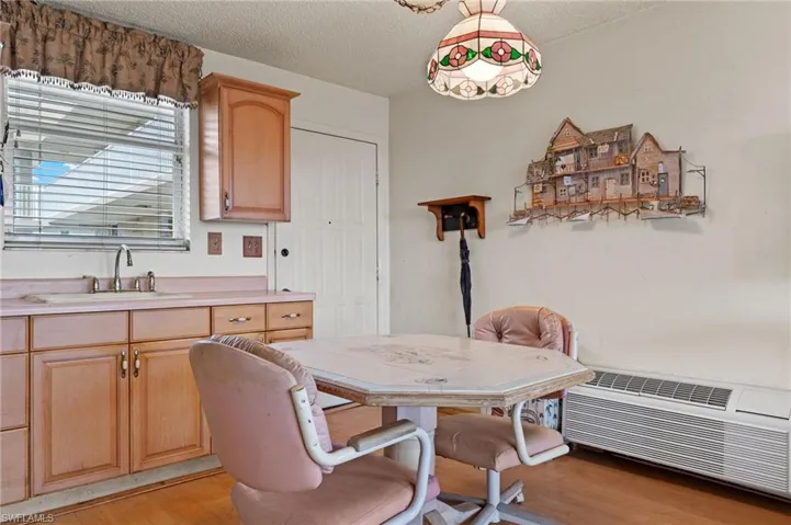 Dining space featuring sink, light wood-type flooring, and a textured ceiling