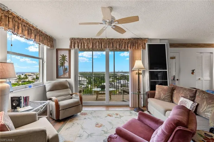 Living room with ceiling fan, light hardwood / wood-style flooring, and a textured ceiling