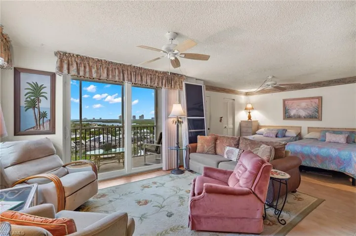 Bedroom featuring ceiling fan, access to exterior, hardwood / wood-style flooring, and a textured ceiling