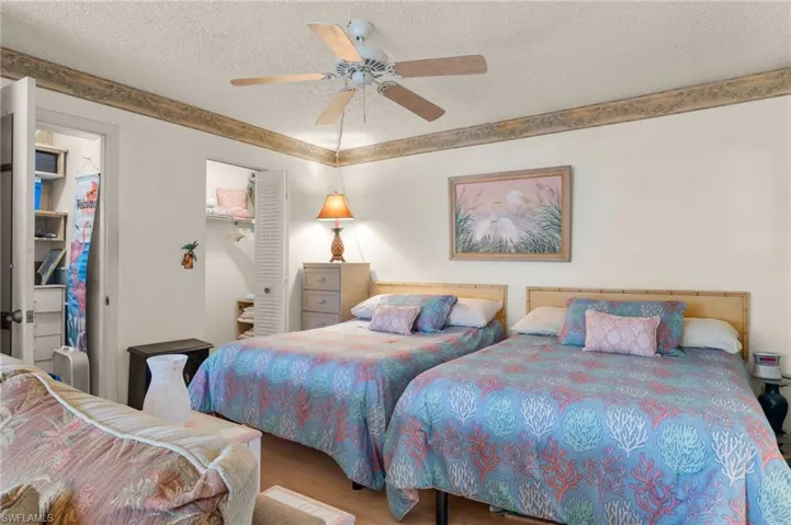 Bedroom featuring a textured ceiling, ceiling fan, hardwood / wood-style flooring, a walk in closet, and a closet
