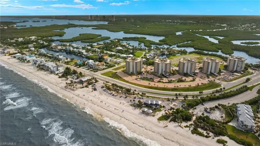 Aerial view featuring a water view and a beach view