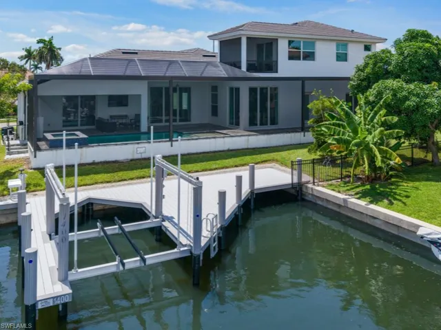 Dock area featuring boat lift, a water view, and a residential view