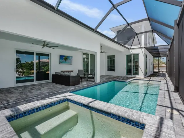 View of swimming pool with a sunroom, a patio, a pool with connected hot tub, ceiling fan, and a lanai