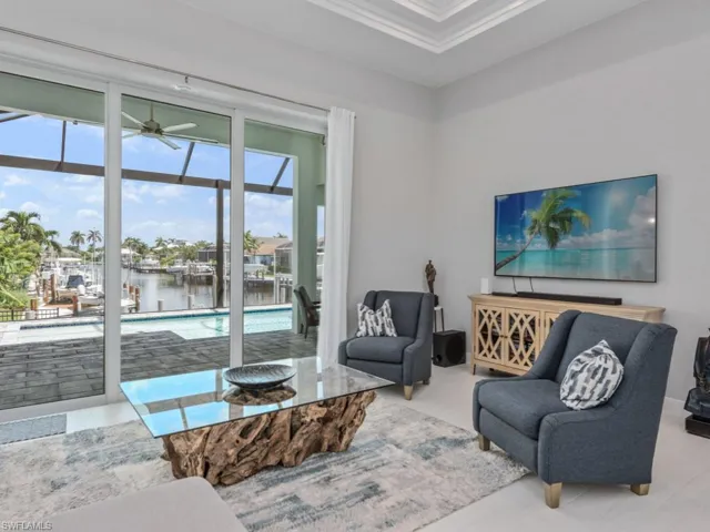 Living room with ornamental molding, a sunroom, and a ceiling fan