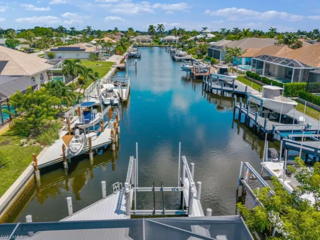 Dock with boat lift, a residential view, and a water view