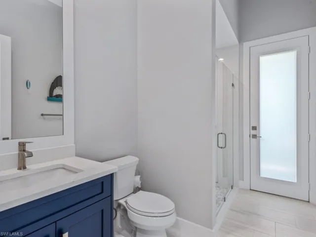 Bathroom featuring healthy amount of natural light, vanity, and a shower stall