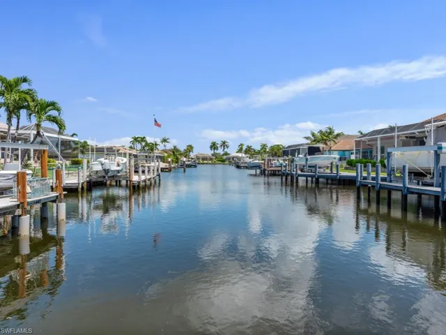 Dock with a water view, boat lift, and a residential view