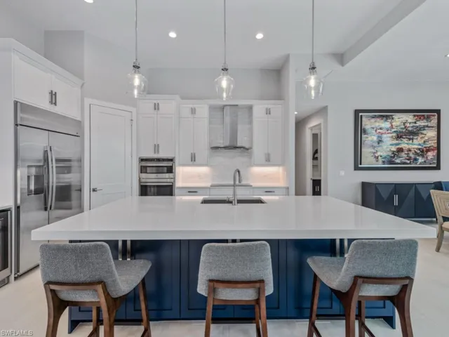Kitchen with stainless steel appliances, tasteful backsplash, hanging light fixtures, recessed lighting, and wall chimney range hood