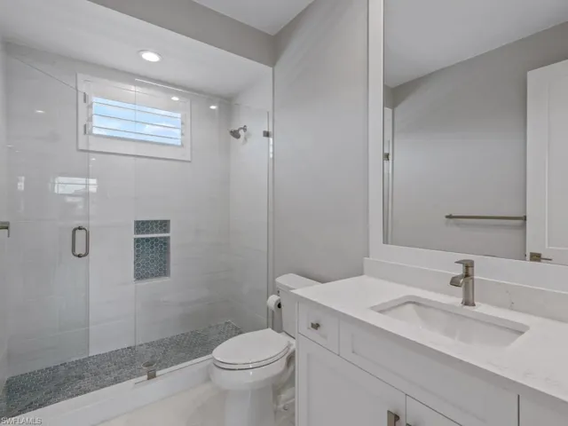 Full bathroom with a stall shower, vanity, and recessed lighting