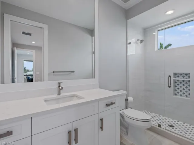 Bathroom with a shower stall, vanity, and recessed lighting