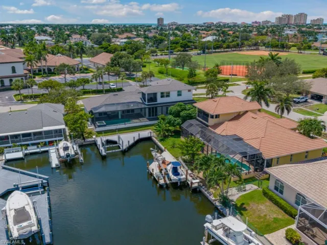 Dock featuring boat lift, a water view, and a yard