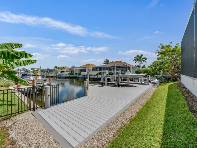 Dock featuring boat lift, a water view, and a residential view