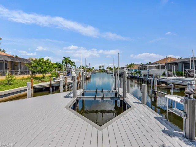 Dock area featuring boat lift, a water view, and a residential view