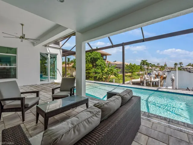 Swimming pool featuring a patio area, a water view, a sunroom, and outdoor lounge area