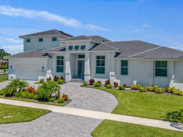 Prairie-style home featuring a garage, decorative driveway, a tile roof, and stucco siding