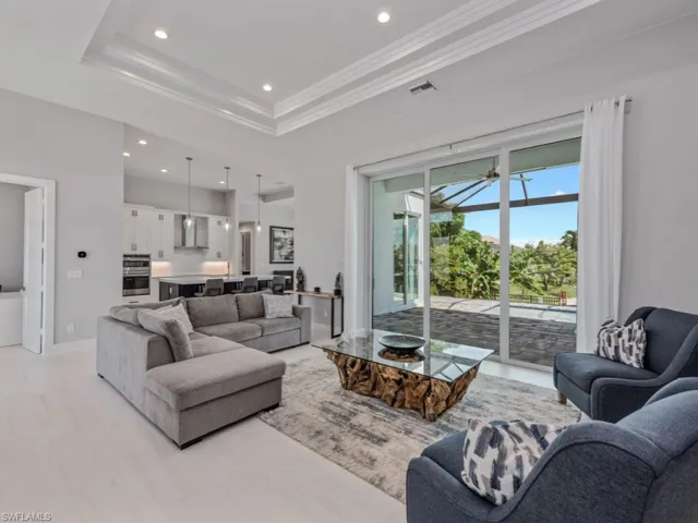 Living room featuring recessed lighting, crown molding, a tray ceiling, and ceiling fan