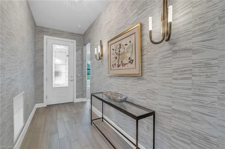 Foyer entrance with wood-type flooring and tile walls