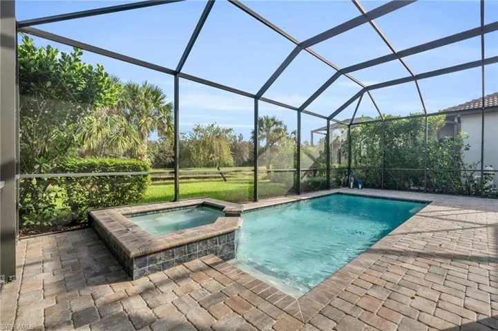 View of swimming pool featuring an in ground hot tub, a patio area, and a lanai