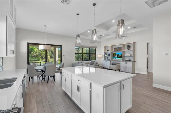Kitchen featuring pendant lighting, white cabinetry, light wood-type flooring, and a kitchen island