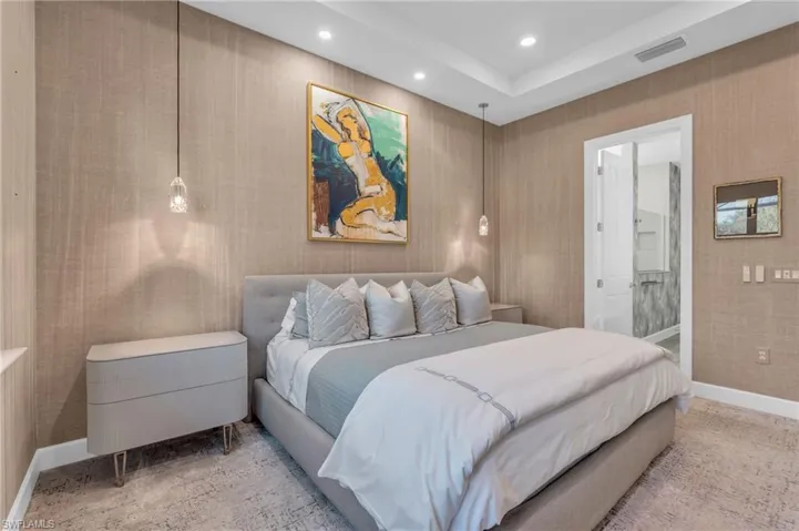 Carpeted bedroom featuring ensuite bathroom