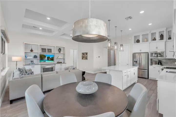 Dining area featuring light hardwood / wood-style flooring, beam ceiling, and coffered ceiling
