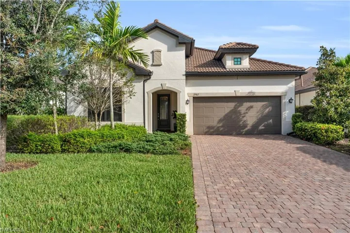Mediterranean / spanish-style house with a front yard and a garage