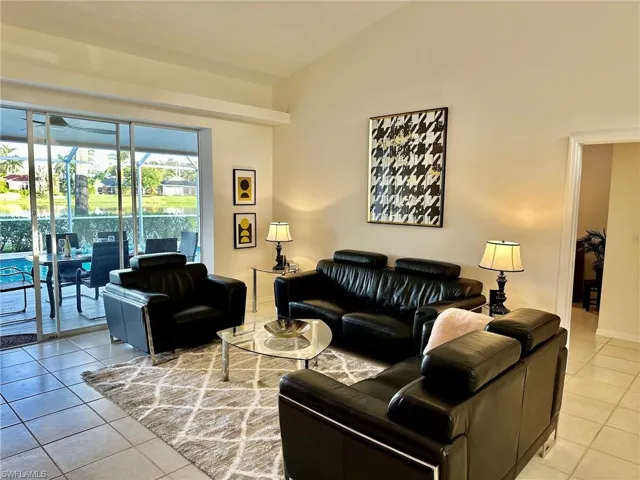 Living area with light tile patterned flooring and high vaulted ceiling