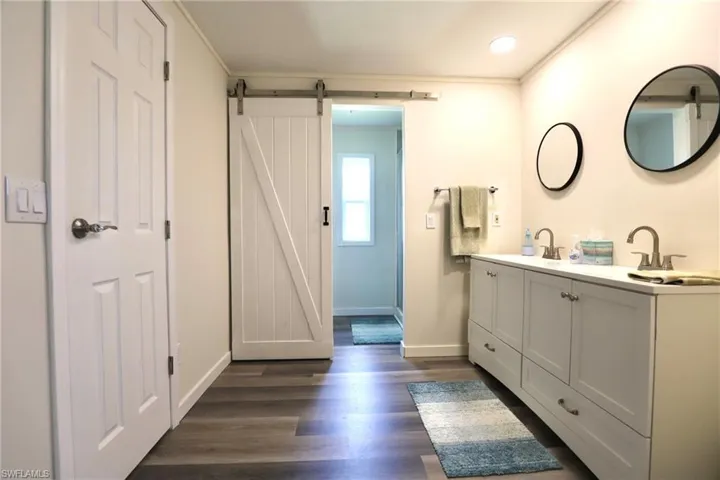 Bathroom featuring vanity, crown molding, and hardwood / wood-style floors