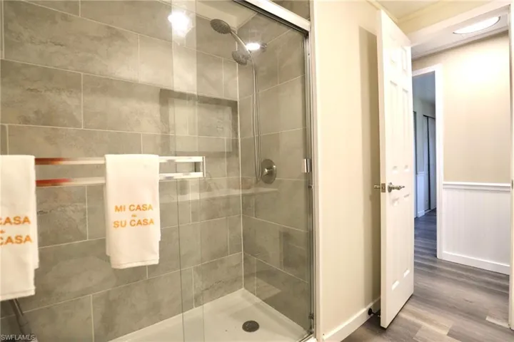 Bathroom with hardwood / wood-style flooring and a shower with door