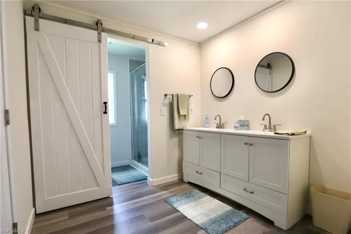 Bathroom featuring an enclosed shower, hardwood / wood-style flooring, and vanity
