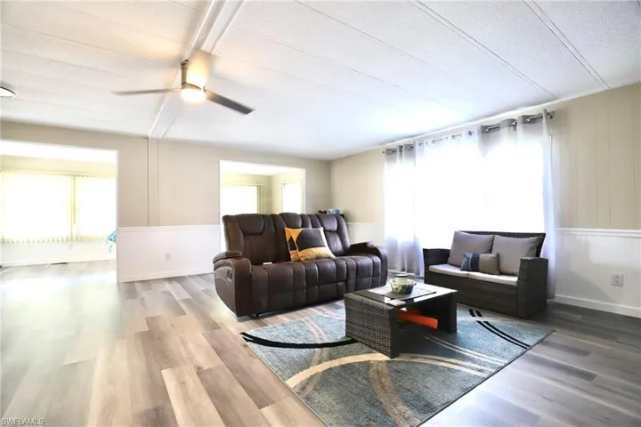 Living room with ceiling fan, hardwood / wood-style floors, and a textured ceiling