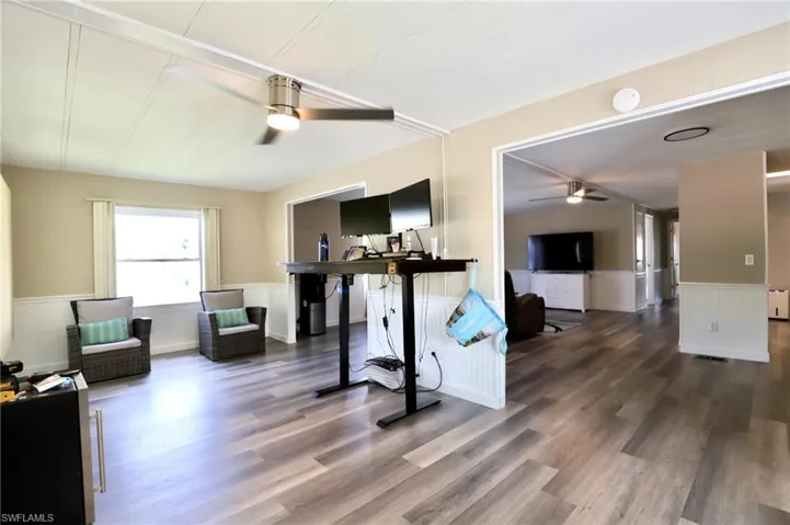 Workout room with ceiling fan and dark wood-type flooring