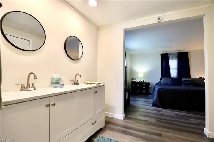 Bathroom with vanity, hardwood / wood-style flooring, and crown molding