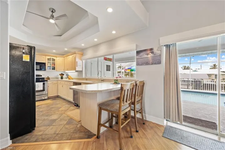 Kitchen featuring appliances, ceiling fan, recessed lighting, a peninsula, and light countertops