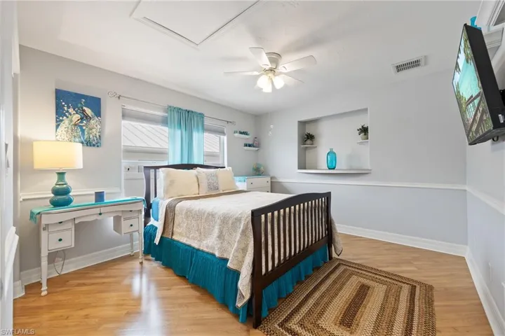 2nd Bedroom featuring laminate floors, built in shelf, and a ceiling fan