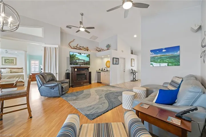 Living area with a ceiling fan, laminate floors, and vaulted ceiling