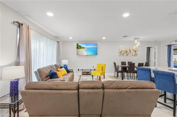 Open-concept living area with recessed lighting and light-toned walls