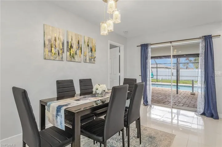 Dining area with polished tile flooring, a contemporary chandelier, and direct access to the outdoor patio